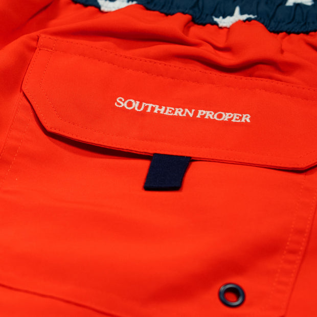 The red swim trunk features a pocket with the product name "Southern Swim - Solid" and an elastic waistband.