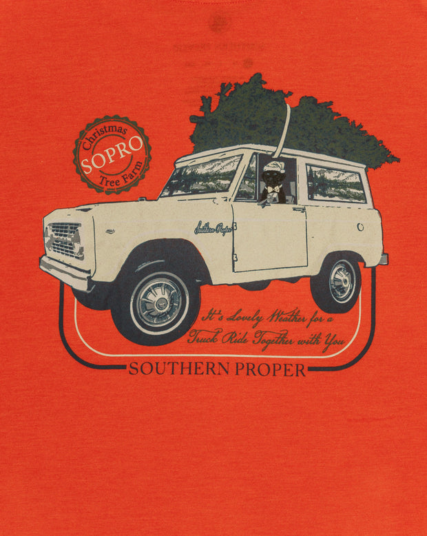 A Lovely Weather LS Tee: Cardinal from our collection, featuring a printed logo of a jeep with a Christmas tree on it.