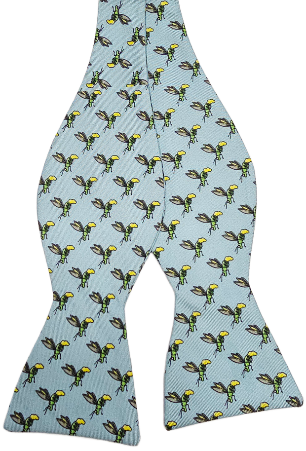 The Firefly Bow: Low Country Blue is a light blue self-tie bow tie with a repeating pattern of cartoon fireflies featuring yellow and black stripes and green wings.