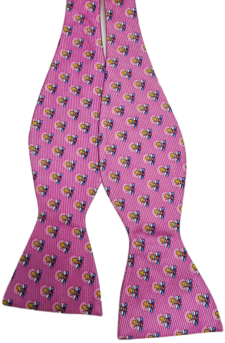 The Firefly Bow: Pink is a self-tie bow tie from Southern Proper, featuring a pink background with a repeating pattern of small multicolored bees.