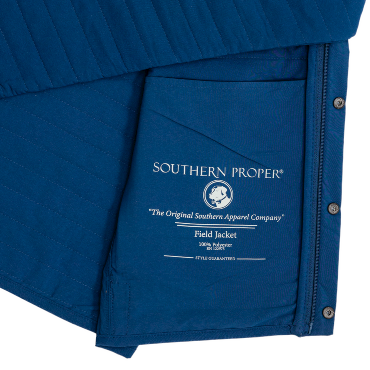 A versatile, Quilted Field Jacket in a stunning blue color, showcasing the words "southern proper" on it.
