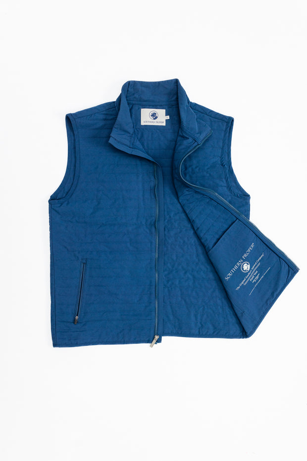 A Quilted Field Vest in blue, perfect for your golf swing, showcased elegantly against a crisp white background.