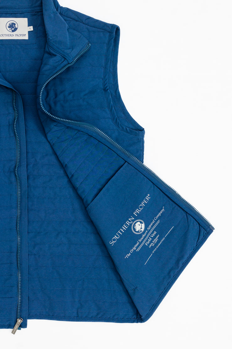 A blue Quilted Field Vest with a pocket on the front by Southern Proper.