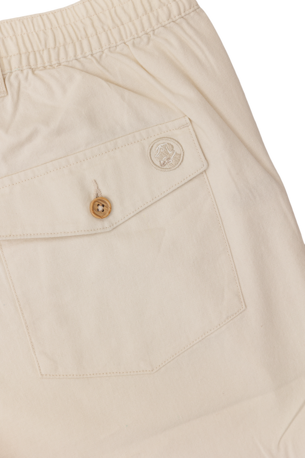 A pair of PC shorts: Stone with an elastic waist and a pocket on the side.