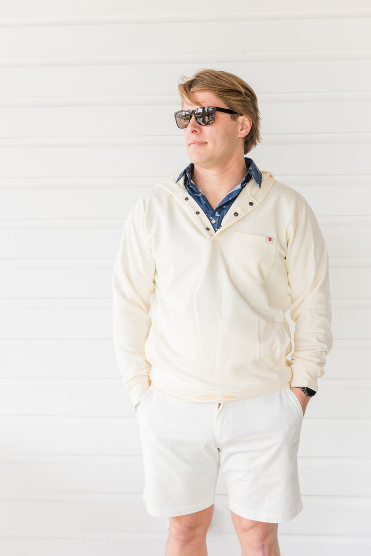 A man wearing a Poydras Hoodie, a relaxed fit white sweater that provides southern comfort.
