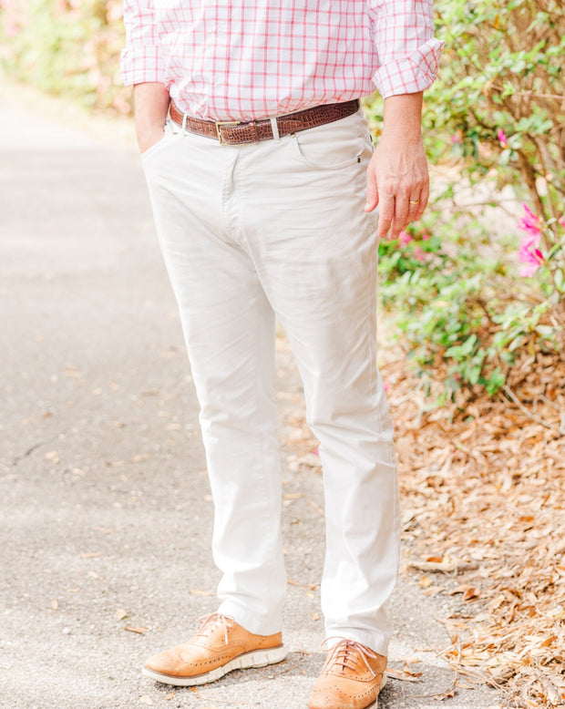 A man wearing a pink shirt and a pair of Needle Creek Five Pocket Pants in a traditional fit.
