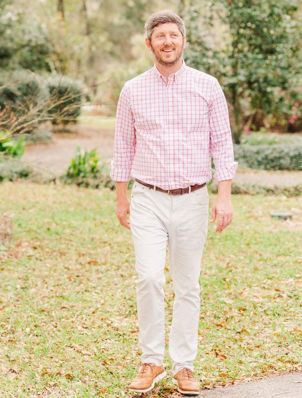 A man wearing a pink gingham shirt and the Needle Creek Five Pocket Pant with a Southern Proper Stamped Patch.