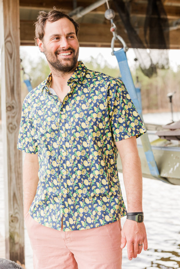 A man is standing on a dock wearing a Cocktail Shirt: Just Add Lemons.