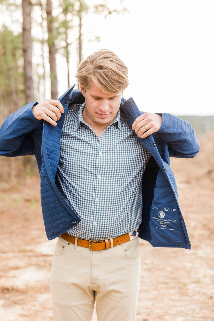 A versatile young man, donned in a quilted field jacket and khaki pants, explores the woods wearing the Quilted Field Jacket.