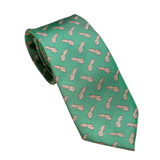 A Southern Proper SP Necktie - Peanut featuring golf shoes on a green background.